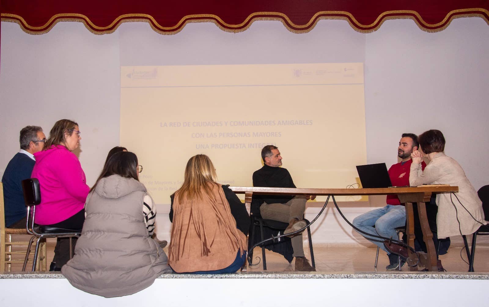 Grupo de personas en torno a una mesa durante la presentación del proyecto piloto de digitalización de la atención social a las personas mayores