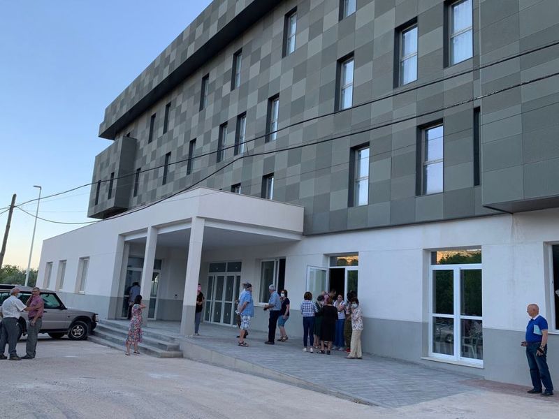 Fachada principal del Balneario de Frailes, el primer Senior Cohousing rural de Andalucía, con personas reunidas en la entrada.